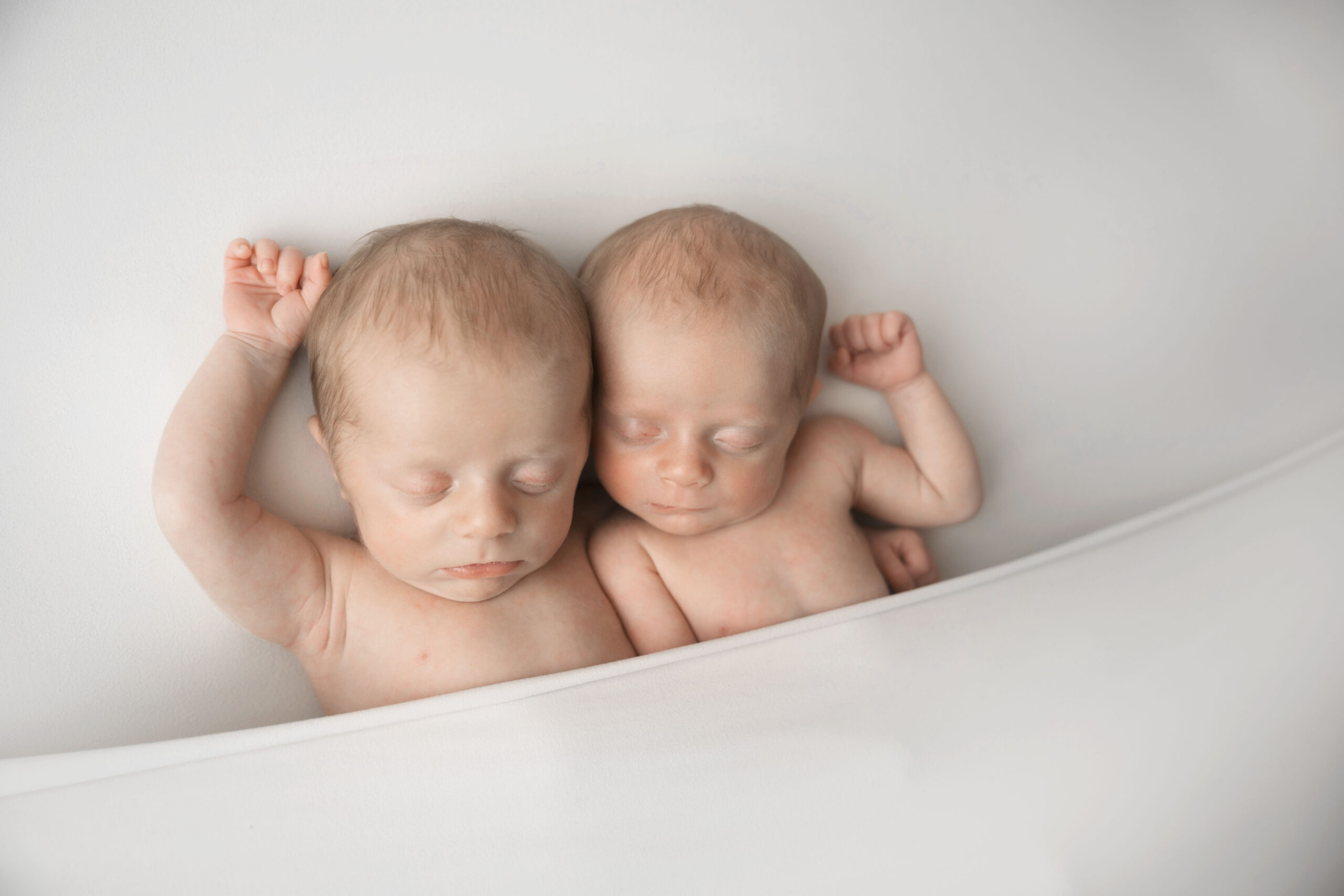 Newborn baby Twins lay in bed together in St. Louis.